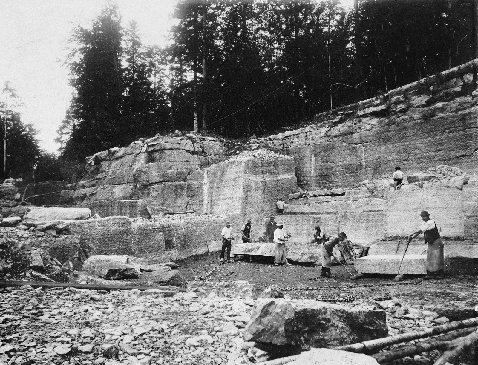 Historische Schwarzweißaufnahme von Arbeitern vor einer abgetreppten Felswand im Lienbacherbruch