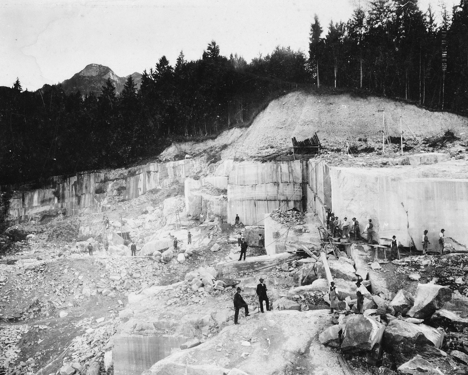 Historische Schwarzweißaufnahme des Steinbruchs am Untersberg mit Arbeitern und Steinblöcken