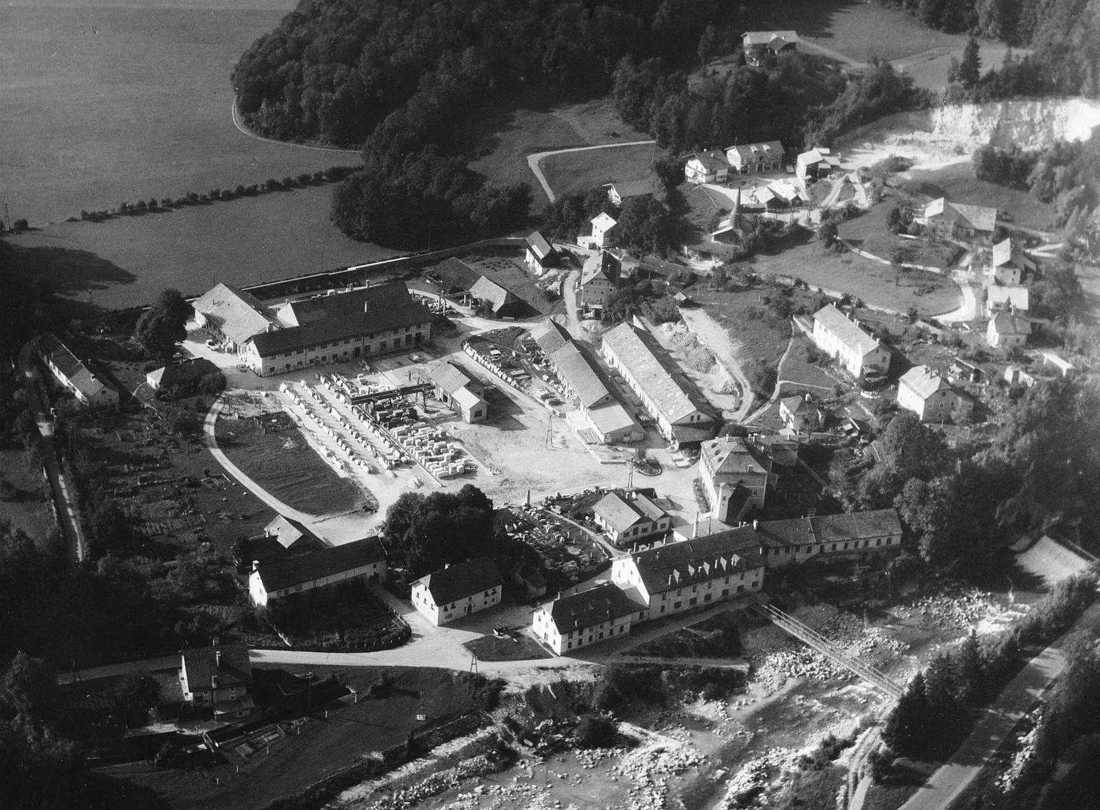 Historische Schwarzweiß-Luftaufnahme des Werksareals in Oberalm mit Hallen und Lagerplätzen