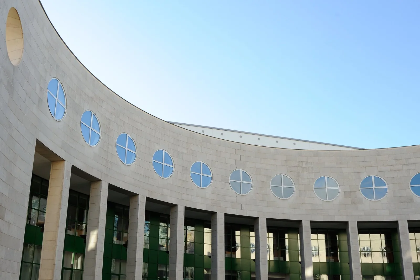 Gerundete Fassade aus hellem Untersberger Marmor mit Säulengang